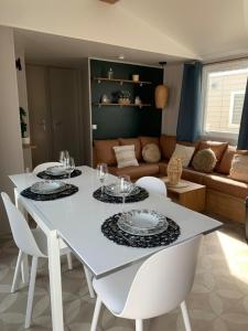 a white dining table with white chairs and a living room at Cb - Espace & confort, 3 ch, 41m2, proche mer in Lattes