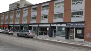 un edificio de ladrillo con coches estacionados frente a él en Duvernay Studios and Suites en Gatineau