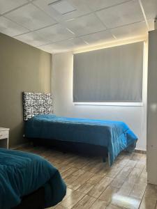 Zimmer mit 2 Betten und einer Tafel in der Unterkunft Adonay VGB in Villa General Belgrano