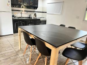 eine Küche mit einem schwarzen Tisch und schwarzen Stühlen in der Unterkunft Adonay VGB in Villa General Belgrano + 8 Fotos