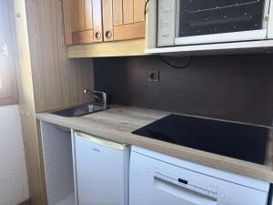 La cuisine est équipée d'un évier, d'un four micro-ondes et d'un lave-vaisselle. dans l'établissement Résidence Cristallin - Le Cristallin 33 - Agréable 2 pièces au pied des pistes MAE-5454, à Valmorel