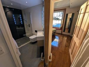 a bathroom with a shower and a toilet and a sink at The Lawns Spa Apartment in Holt +10 photos