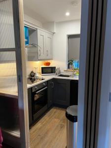 eine Küche mit schwarzen Schränken und weißen Arbeitsplatten in der Unterkunft The Bath House & Sauna Garden x 4 beds in Newcastle