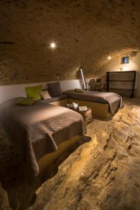 a bedroom with two beds in a stone wall at Le Jas de Péguier in Châteauneuf-Val-Saint-Donat