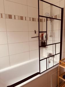 a white bath tub with a glass shelf next to it at Ferienwohnung „Göttschied“ in Idar-Oberstein +47 photos
