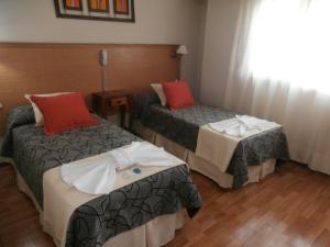 a hotel room with two beds and a window at Hotel Alma di Mare MDP in Mar del Plata