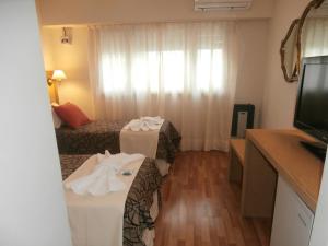 a hotel room with a bed and a television at Hotel Alma di Mare MDP in Mar del Plata +10 photos