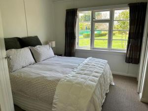 a bedroom with a bed and a window at Hawkesbury Cottage in Clive