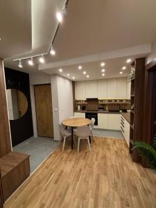a kitchen and dining room with a table and chairs at Šumska staza Divčibare apartmani in Divčibare