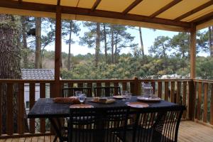 a table on a screened porch with a table and chairs at Mobilhome Les Embruns by Siblu in Lège-Cap-Ferret +11 photos