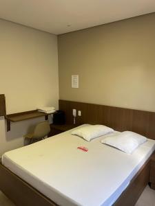 a bedroom with a large white bed with a desk at Hotel Max Tatuapé in Sao Paulo +10 photos
