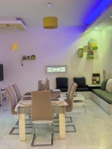 a dining room with a table and chairs and a couch at Grace house jacuzzi in Saly Portudal