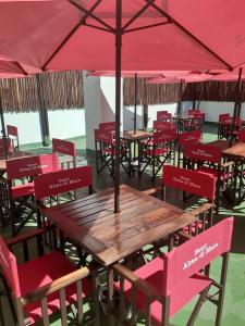 a wooden table and chairs with a red umbrella at Hotel Alma di Mare MDP in Mar del Plata