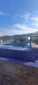 una piscina con azulejos azules en la parte superior de un edificio en Penthouse #1 - Piso 5 Basilio, en Puerto Vallarta