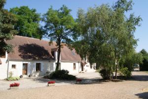 La Bihourderie في Azay-sur-Indre: منزل أبيض وبه أشجار وزهور في الممر