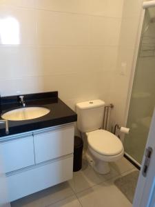 ein weißes Badezimmer mit Toilette und Waschbecken in der Unterkunft Flat Por Temporada no Edifício Time Maceió-AL in Maceió + 8 Fotos