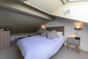 um quarto com uma grande cama branca em um quarto em Résidence Bergerie Des 3 Vallees C - Joli appartement 3 pièces 4 personnes situé sur Les Allues dans un quartier calme MAE-7391 em Les Allues