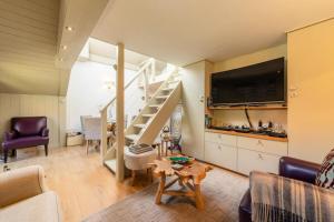 uma sala de estar com uma escada e uma televisão em Résidence Bergerie Des 3 Vallees C - Joli appartement 3 pièces 4 personnes situé sur Les Allues dans un quartier calme MAE-7391 em Les Allues