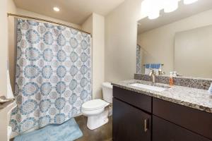 a bathroom with a toilet and a shower curtain at The West End Flats Hotel in Roanoke +13 photos