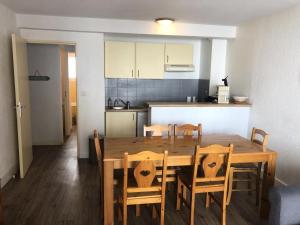 a kitchen and dining room with a wooden table and chairs at Résidence Hauts De Peyragudes Mp - T3/8pers -HAUT DE PEYRAGUDES C10- Peyresourde MAE-7481 in Germ