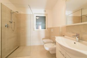 a bathroom with a toilet and a sink and a shower at Garni B&B Apartments Plank in Nova Levante +59 photos