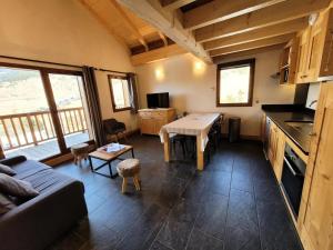 ein Wohnzimmer mit einem Tisch und einem Sofa sowie eine Küche in der Unterkunft Résidence Le Criterium - Résidence Le Critérium 3Chalet E Appartement 8 MAE-7751 in Lanslebourg-Mont-Cenis