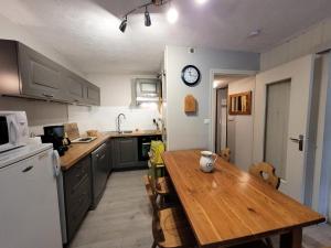 a kitchen with a wooden table and a counter top at Résidence Foret-erable - Petit 2 pièces chaleureux et bien équipé MAE-7781 in Bonneval-sur-Arc