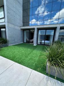 a yard of green grass in front of a building at Apartamento em Xangri-lá in Xangri-lá