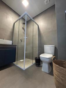 a bathroom with a shower with a toilet and a sink at Apartamento em Xangri-lá in Xangri-lá