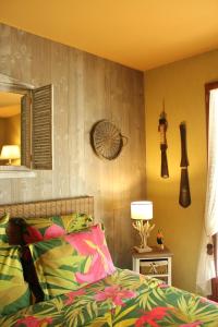 a bedroom with a bed and a mirror and a lamp at Via Bahia - Maison d'hôtes in Biscarrosse