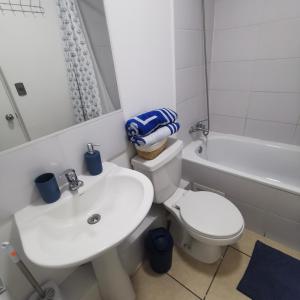 a bathroom with a sink and a toilet and a bath tub at Dpto Playa Casino Marina Sol in Coquimbo +10 photos