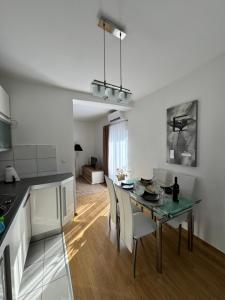 eine Küche und ein Esszimmer mit Tisch und Stühlen in der Unterkunft Apartman Alpeza in Grude + 6 Fotos