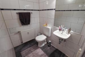 a white bathroom with a toilet and a sink at Central Messe Airport DUS Apartment with Terrace in Duisburg