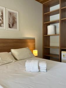 a bedroom with a bed with two towels on it at Hotel Roma in São Sebastião