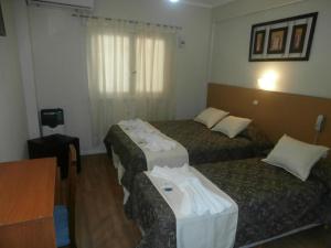 a hotel room with three beds with towels on them at Hotel Alma di Mare MDP in Mar del Plata