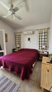 Un dormitorio con una cama grande con una colcha roja. en Casa planta alta 2 dormitorios, en Valle Hermoso 23 fotos más