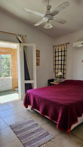 Un dormitorio con una cama y un ventilador de techo. en Casa planta alta 2 dormitorios, en Valle Hermoso