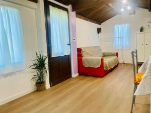 a room with a red couch and a window at B&B in fattoria in Rivalta di Torino