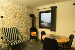 Cette chambre dispose d'une table et d'un poêle à bois. dans l'établissement Anielskie Wzgórze Domek z Widokiem & Kuźnia Skarbów, à Mokre