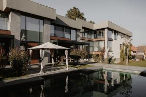 a building with an umbrella next to a swimming pool at Di' Wine House Fruška Gora in Irig