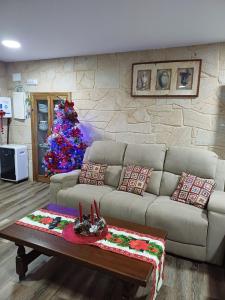 a living room with a couch and a christmas tree at O Cobo Vacacional in Padrón