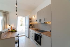 a kitchen with white cabinets and a counter top at Manifesto Seaview Apartment I in Kalymnos +15 photos