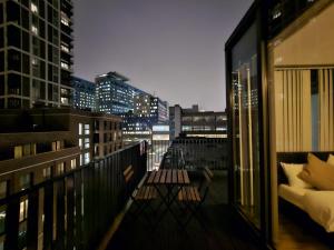 a balcony with a view of a city at night at Penthouse - Whitechapel in London