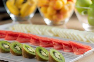 a plate of food with kiwi and watermelon at AC Hotel by Marriott Tenerife in Santa Cruz de Tenerife