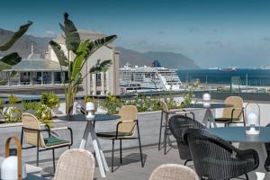 a patio with tables and chairs and a cruise ship at AC Hotel by Marriott Tenerife in Santa Cruz de Tenerife