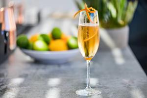 a glass of champagne on a counter with a bowl of fruit at AC Hotel by Marriott Tenerife in Santa Cruz de Tenerife
