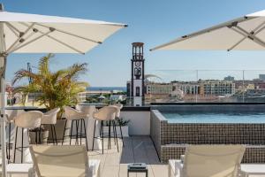a rooftop bar with chairs and a swimming pool at AC Hotel by Marriott Tenerife in Santa Cruz de Tenerife