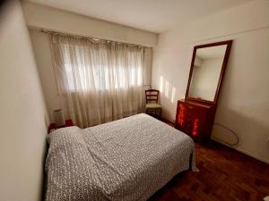 1 dormitorio con cama, espejo y tocador en Departamento Zona Varese Piso 12, en Mar del Plata 30 fotos más