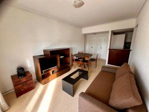 una sala de estar con un sofá y una mesa en Departamento Zona Varese Piso 12, en Mar del Plata