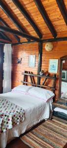Un dormitorio con una cama en una cabaña de madera. en De la Montaña, en Duitama